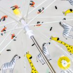 Children's umbrella with jungle animal print featuring zebras, giraffes, and toucans.